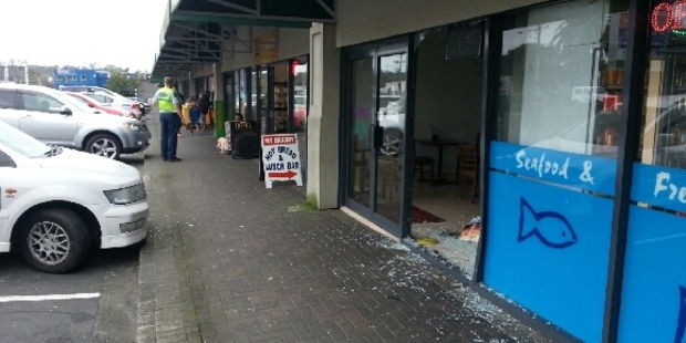 Police are at the scene where a car smashed through a shop window on Great North Rd in Kelston on Tuesday morning. Photo/ Ben Rose