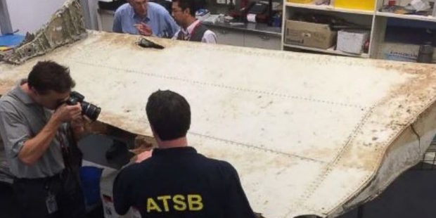 Australian Transport Safety Bureau investigators examine the wing flap from MH370. Photo / ATSB