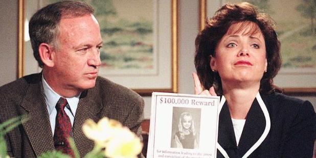 John Ramsey looks on as his wife Patsy holds an advertisement promising reward for information leading to arrest and conviction of murderer of their daughter JonBenet. Photo / AP