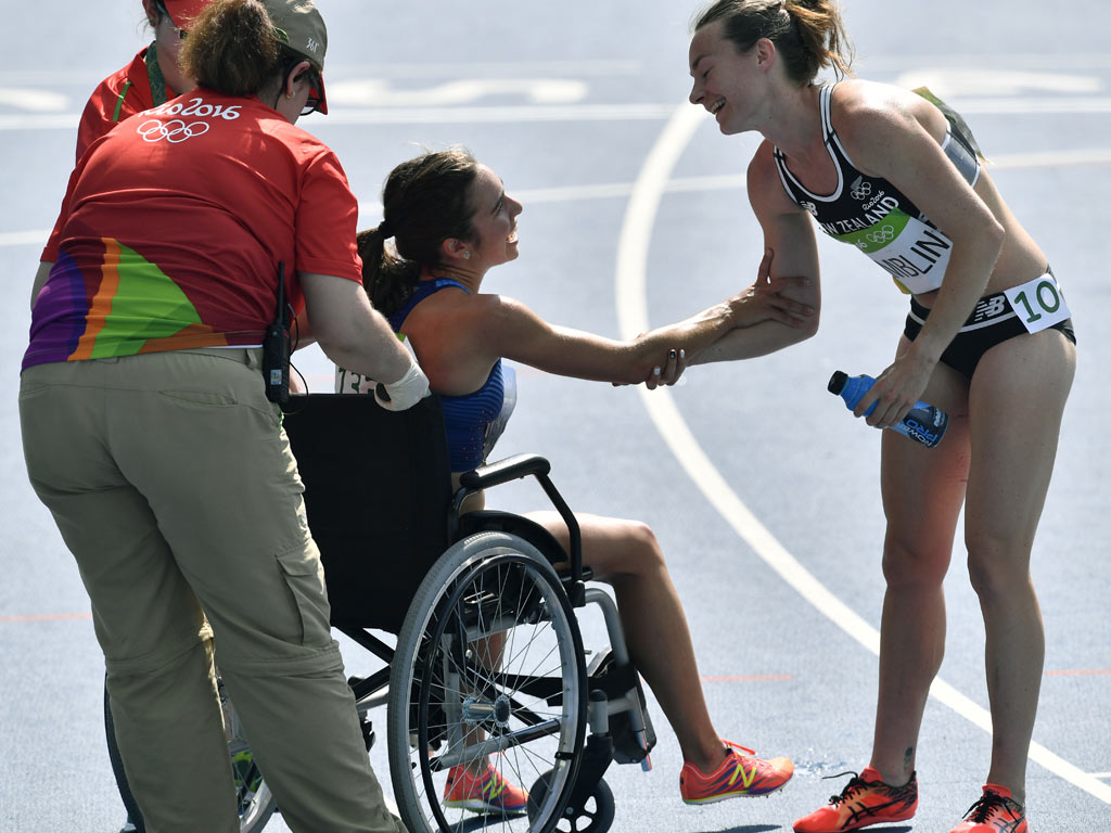 New Zealand's Nikki Hamblin greets United States' Abbey D'Agostino, left, as she is helped from the track after competing in a women's 5000-meter . AP