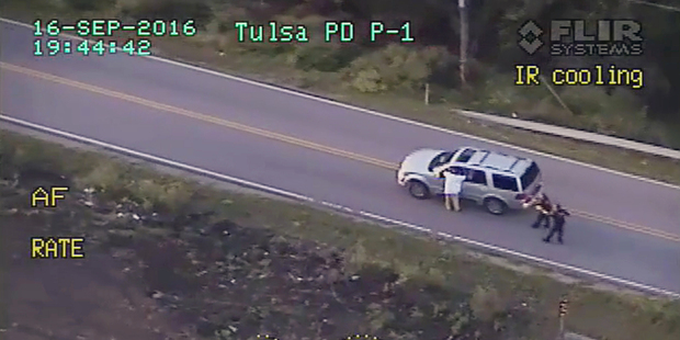 Police video shows Terence Crutcher with his arms up as he is pursued by police officers. Photo / AP