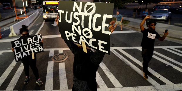 Protesters block an intersection near the Transit Center as they march uptown in Charlotte. Photo / AP