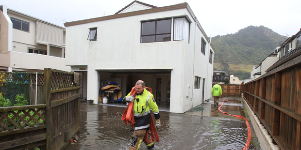 Firemen pump water out of a flooded Commons Ave property at Mount Maunganui in 2013. Photo/File