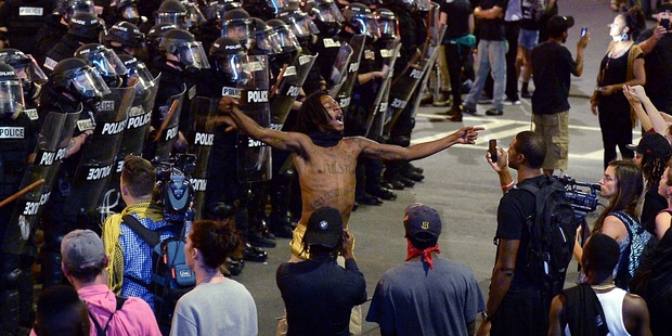 Protesters and police face off on the streets of Charlotte on the second night of demonstrations after Keith Lamont Scott was shot dead by police. Picture / AP