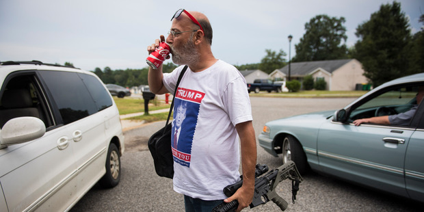 Jim Cooley carries his AR-15 semiautomatic rifle into his home after having it fixed. Cooley almost never leaves his home unarmed. Photo / The Washington Post / Jabin Botsford