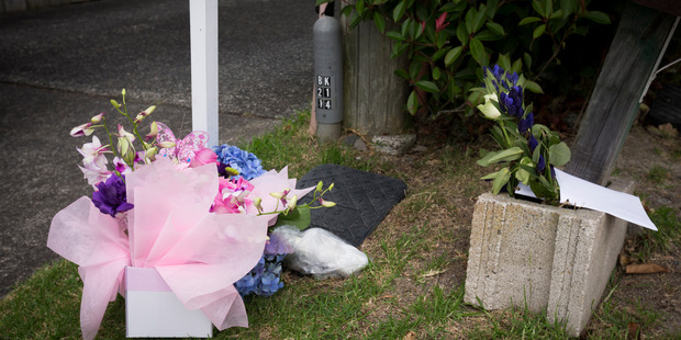 Flowers and cards are placed at the scene. Photo / Dean Purcell