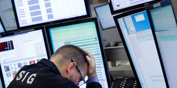 A trader rests his head in his hand at the New York Stock Exchange. Photo / AP