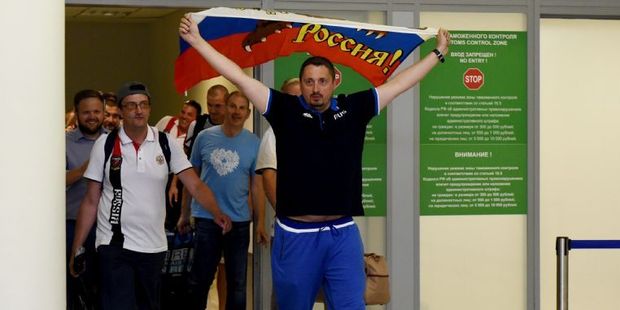 Russia's football fans leader Alexander Shprygin holding a flag as he leaves with other fans the international Sheremetevo airport near Moscow after being expelled from France. Photo / AFP
