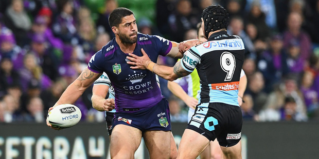 Jesse Bromwich passes the ball whilst being tackled by Michael Ennis. Photo / Getty Images