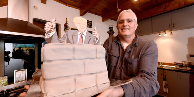 Matthew Koch with a 'Trump's wall' cake, at an ex-pat gathering to watch the first US presidential debate. PHOTO/GEORGE NOVAK