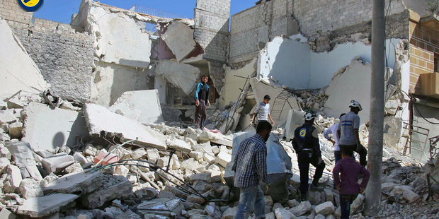 Members of Civil Defense inspecting damaged buildings after airstrikes hit the Bustan al-Qasr neighborhood of Aleppo, Syria. Photo / AP