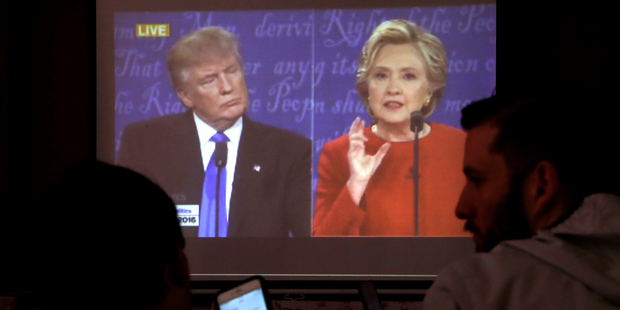 People chat as they watch a live broadcasting of the debate. Photo / AP