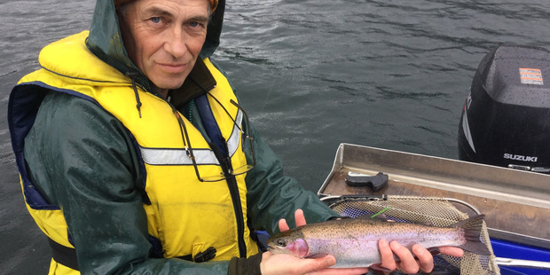 TROUT: Fish and Game officer Mark Sherburn holds a green tag trout before releasing it. PHOTO/SUPPLIED