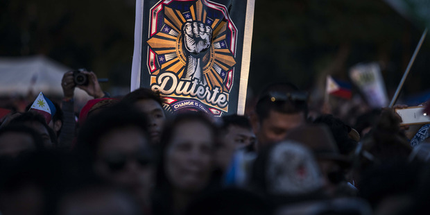 An attendee holds a sign on May 7 in support of a Rodrigo Duterte, who was at the time mayor of Davao City and a presidential candidate. Photo / Taylor Weidman, Bloomberg