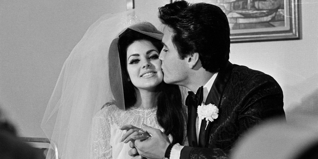 Elvis Presley gives his new bride, Priscilla Ann Beaulieu, a kiss following their wedding. Photo / Getty 