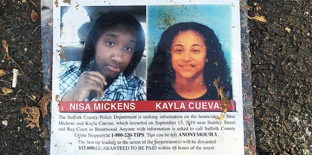 A poster featuring photos of Nisa Mickens and Kayla Cueva is part of a memorial near the spot where their bodies were found in Brentwood, N.Y. Photo / AP