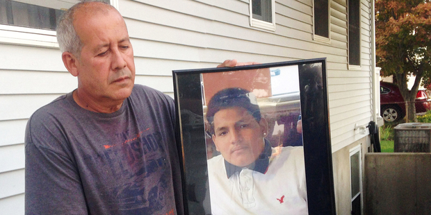 Abraham Chaparro, holds a photograph of his murdered stepson, Miguel Garcia-Moran, outside his home in Brentwood, N.Y. Photo / AP
