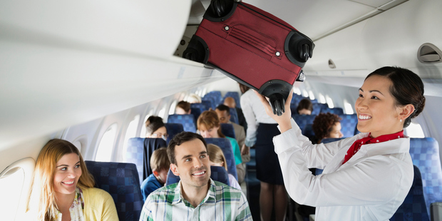 Don't let the smiles fool you - flight attendants are fed up with your bad behaviour. Photo / Getty Images