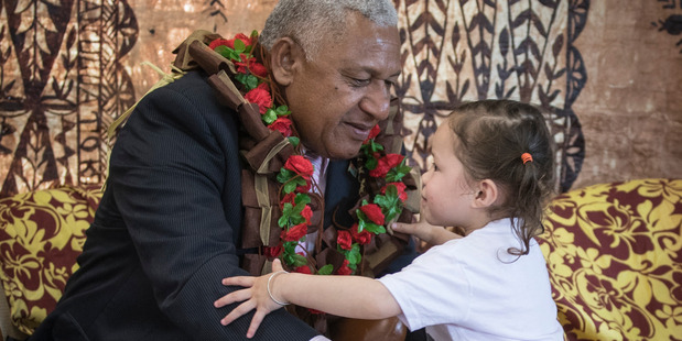 Fiji Prime Minister Frank Bainimarama is presented with a salu salu by Maraia Kauyaki at Bula Kindergarten in Mangere today. Photo / Greg Bowker