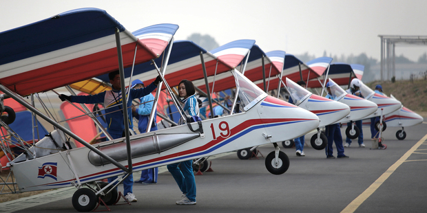 North Korean pilots stand with their ultralight aircraft on the tarmac of the Mirim Air Club. Photo / AP