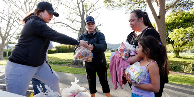 Rachael Beardsall with her daughter Moana Elliott get lunch packs from Hadassah Mahanga, left, and Shirley-Anne Paul. Photo / John Stone