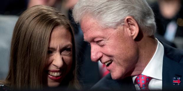 Former President Bill Clinton, right, speaks to his daughter Chelsea Clinton before the third presidential debate at University of Nevada in Las Vegas. Photo / AP