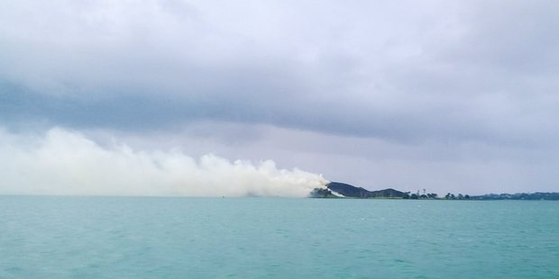 Smoke trailed across the water from the fire on Browns Island. Photo / Aya McKenzie