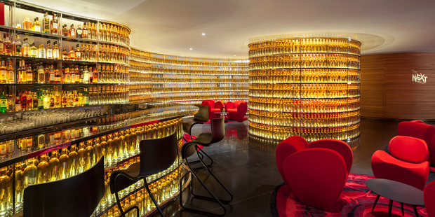 The Watergate Hotel's Next Whisky Bar boasts a curved wall of 2500 illuminated bottles. Photo / Ron Blunt