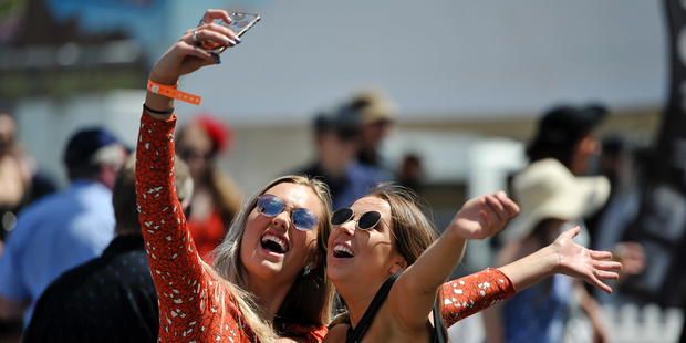 Trotting Cup Day fans capture a selfie moment. Photo / Photosport