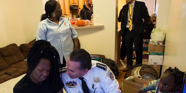 Interim D.C. Police Chief Peter Newsham comforts LaKira as her mother, Cassandra Johnson, and her daughter Kali hover beside her air mattress in October. Photo: Nikki Kahn, The Washington Post.