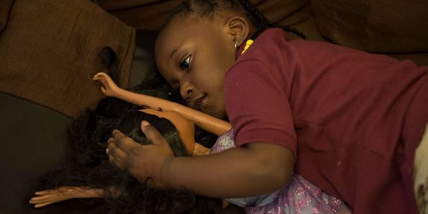 LaKira Johnson's daughter, Kali, 3, cuddles up to a doll. She'd been putting aside toys for her new baby sisters. Photo: Nikki Kahn, The Washington Post