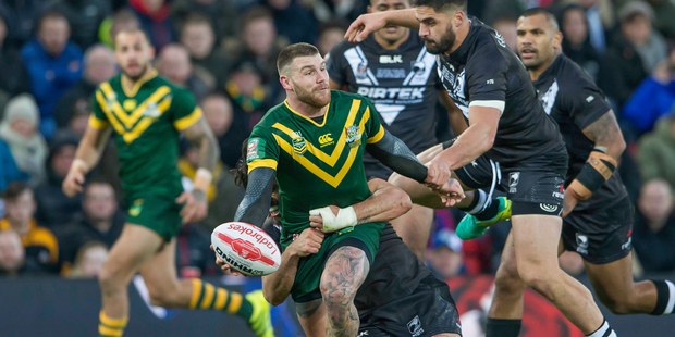 Australian centre Josh Dugan offloads as he's tackled by New Zealand's Tohu Harris and Jesse Bromwich. Photo / Photosport.