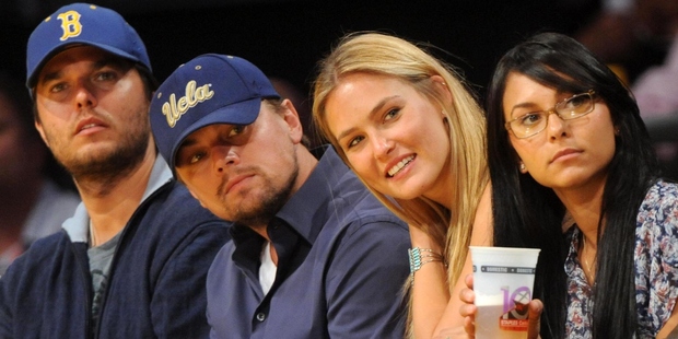 Leonardo DiCaprio (2nd-L) sits courtside with his girlfriend, Israeli model Bar Refaeli (3rd-L) and his stepbrother Adam Farrar (L). Photo / Getty 
