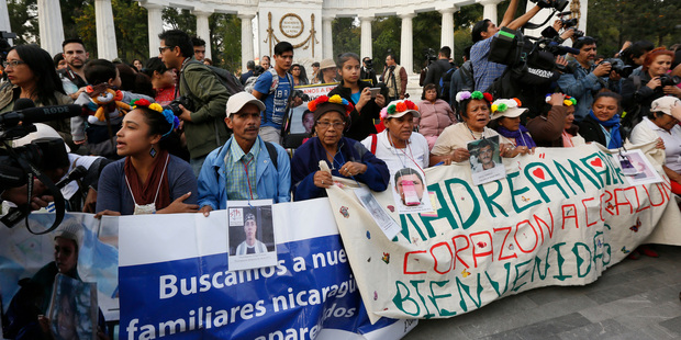 Members of a caravan of Central American mothers hold photographs of their disappeared children during a demonstration in Mexico City today. Photo / AP
