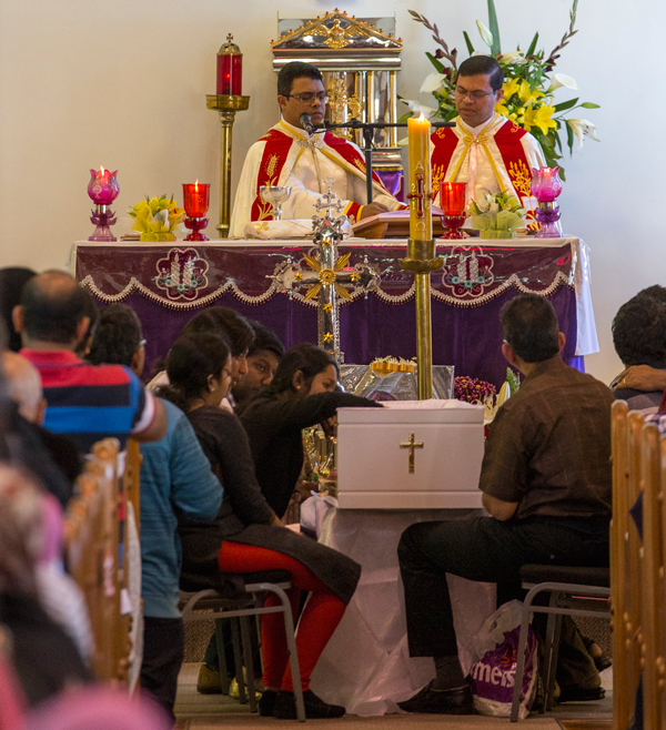 Mourners including family members gather around the casket at the front of the Immaculate Conception Church in Ellerslie at the funeral of 4 year old Aldrich Viju. Photo / Peter Meecham