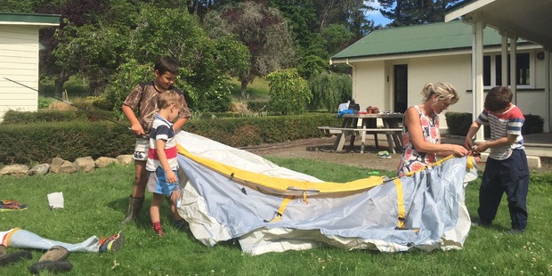 Lizzie Hay and her sons, McGregor, 3, Sam, 6, and Ben, 8, pitch a tent after their house was damaged in last night's aftershock. Photo / Kurt Bayer