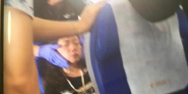 A woman is treated on board the China Eastern flight following air turbulence as it approached Sydney Airport.