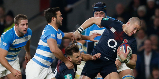 England's Mike Brown carries the ball forward as Argentina's Martin Landjo, left, attempts to tackle during the rugby union international between England and Argentina. Photo / AP.