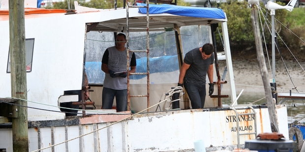 Police search a boat on the Raumanga Stream.
