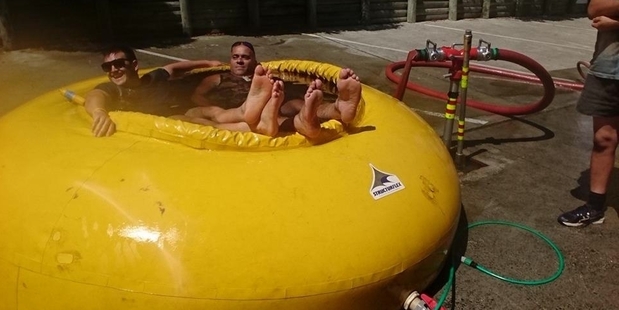 After: firefighters Jarryd Booth (left) and Hauraki Himiona cool off in their portable swimming pool, normally used as a portable dam on fire jobs.