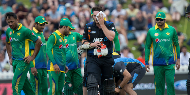 Mitchell McClenaghan leaving the pitch after being hit by a bouncer. Photo / Mark Mitchell