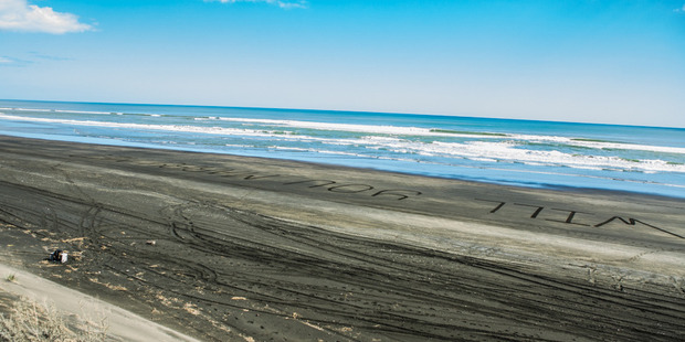 Chris proposed by writing words in the sand at Muriwai beach. Photo / Supplied by Chris Hoffmann