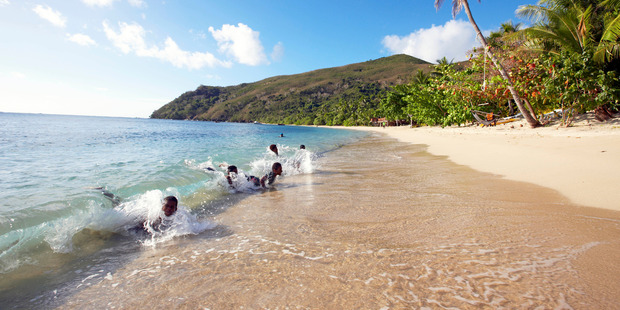 Fijian children playing in the surf.