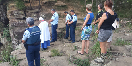 BLESSING: The scene of Tuesday's drowning at Charlie's Rock is blessed by Minister Sid Kingi while police officers and local residents show their respects. PHOTO / SUPPLIED