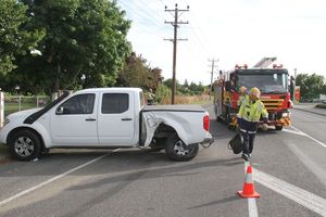 Fire crews pull a vehicle to the side of Ngaumutawa Rd following a collision with a power pole. PHOTO/ANDREW BONALLACK