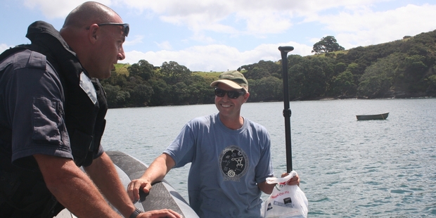 Police Constable Marco van den Broek chats to camper Phillip Mayall, who paddled out from a DoC campground in the Bay of Islands for some fishing information. Photo / DOC