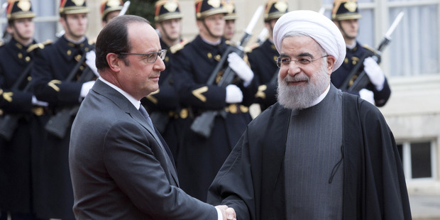 Francois Hollande, France's president welcomes Hassan Rouhani, Iran's president, in the courtyard of Elysee Palace in Paris, France. Photo / Bloomberg