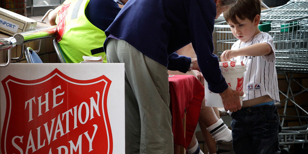 4-year-old Jim Macken (R) donates some money to The Salvation Army collectors at New World in Devonport this afternoon. 20 December 2011 New Zealand Herald Photograph by Sarah Ivey