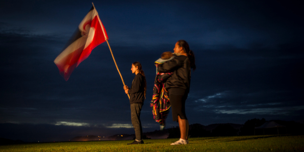 A woman sings a waiata as dawn breaks. Photo / Michael Craig