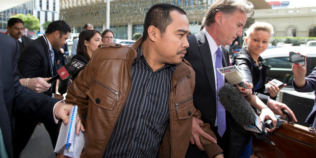 Muhammed Rizalman tries to escape a media scrum in 2014. Photo / Mark Mitchell
